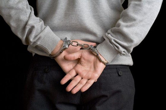 Man in handcuffs on black background