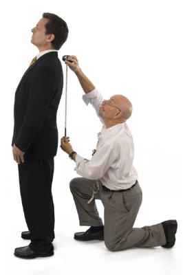 Man getting measured by a tailor on a white background.